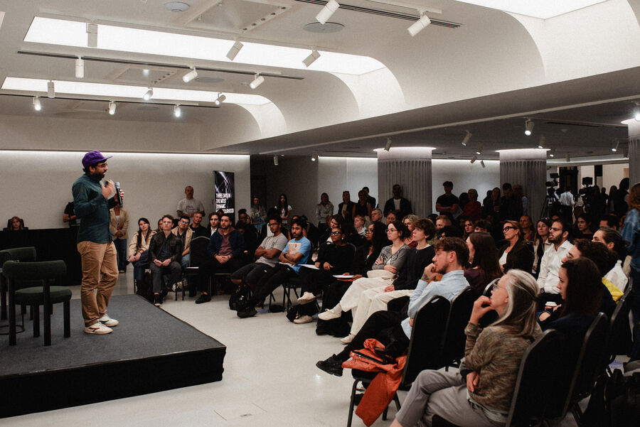 Mahdi Shariff on stage in front of a full room at OffScript Vision Festival 2026