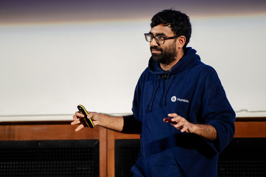 Mahdi Shariff on stage in a Humble hoodie, mid-sentence