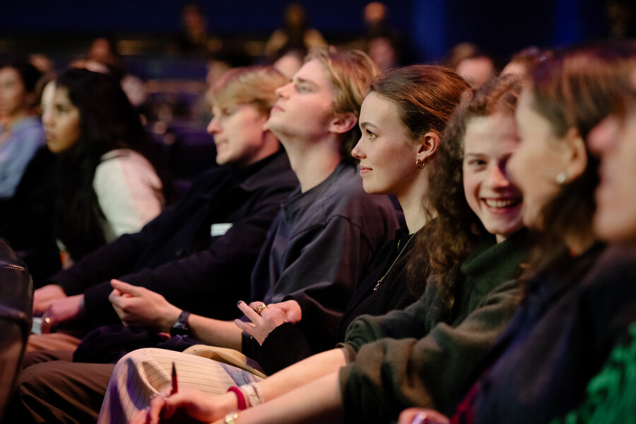 Smiling audience members listening to the talk